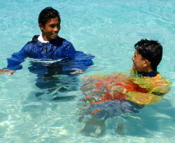 swimming lesson by lifeguard in red and yellow swimwear